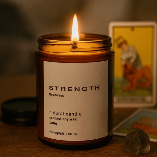 Candle in a container labeled 'Strength' on a wooden surface with a blurred background